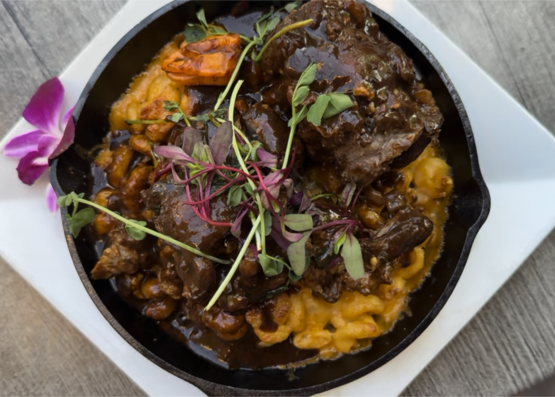 Braised oxtail over creamy smoked gouda mac and cheese